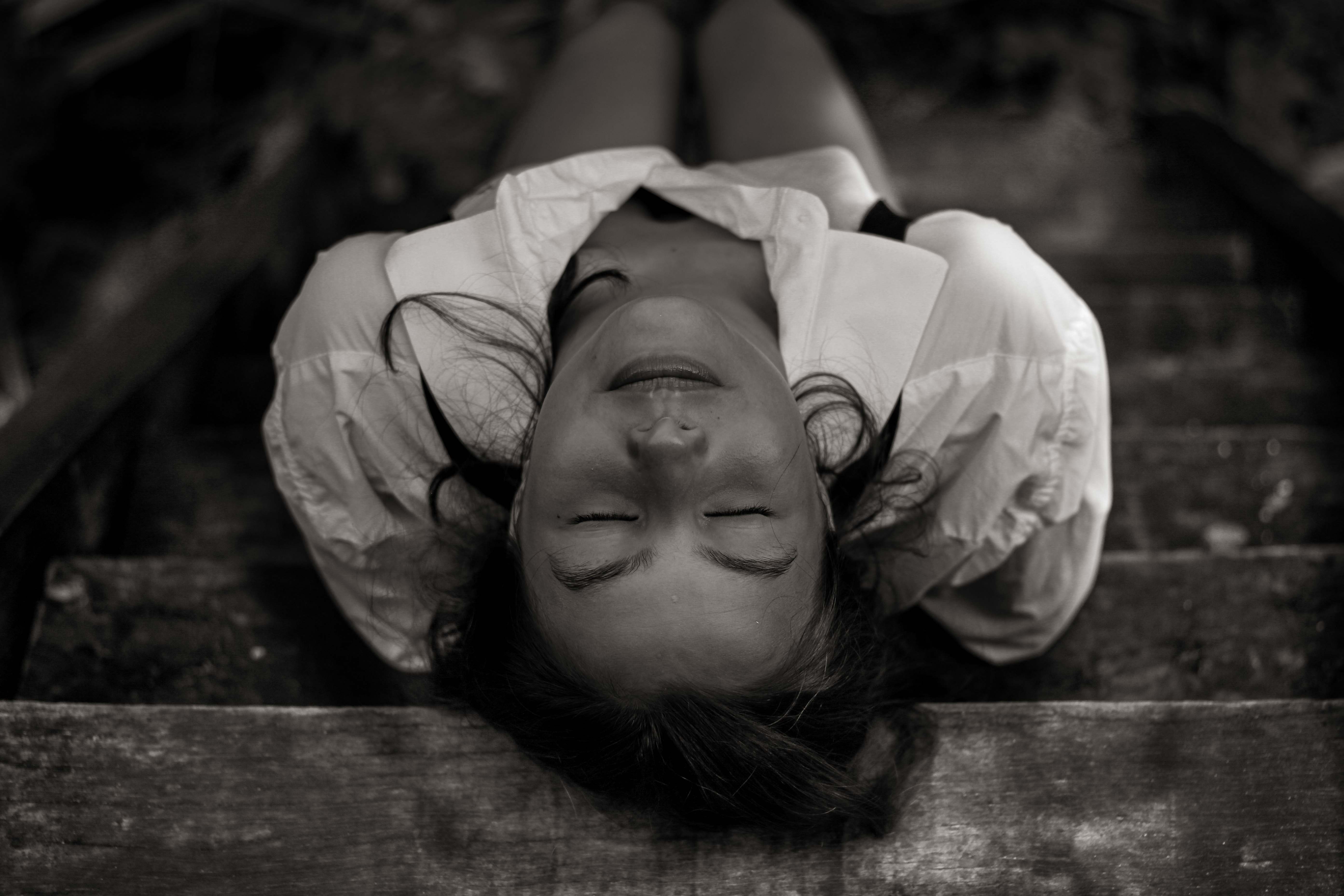 woman in white shirt lying on wooden plank